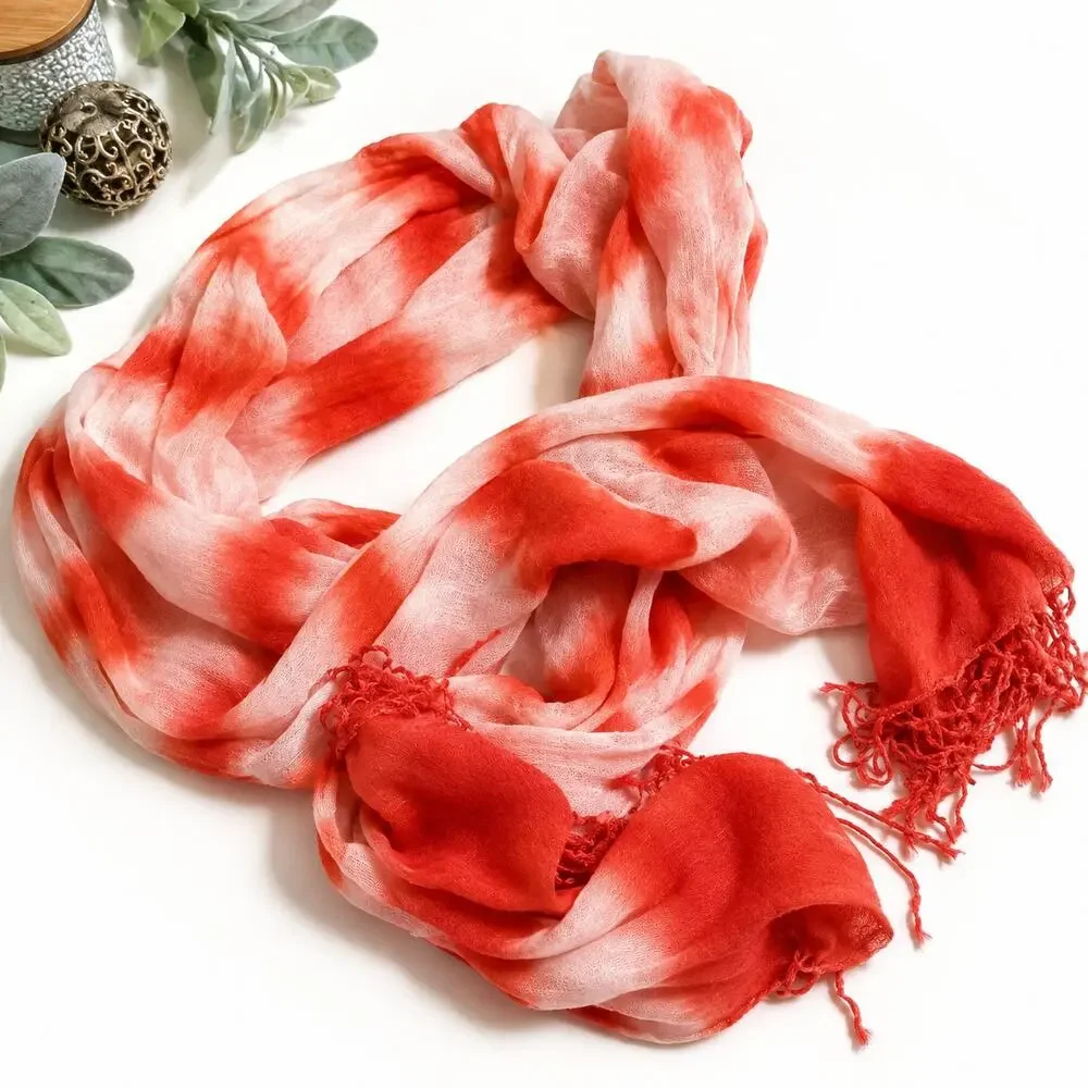 Orange and white lightweight scarf featuring a tie-dye pattern and fringed ends.